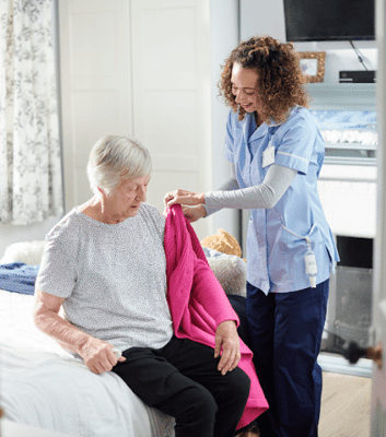 A caregiver assisting a resident in a bedroom