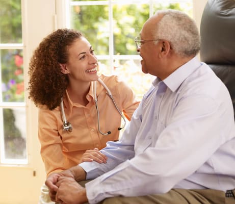 A caregiver interacting with a smiling senior resident