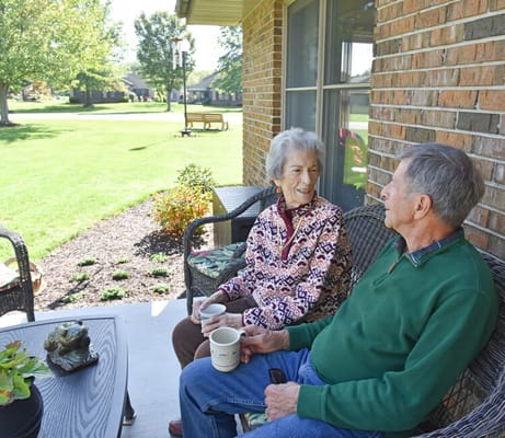 Residents enjoying time on a porch with drinks
