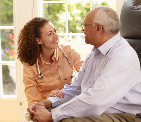 A smiling caregiver interacting with a senior resident