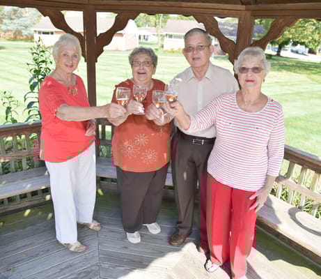 Four residents celebrating in a gazebo