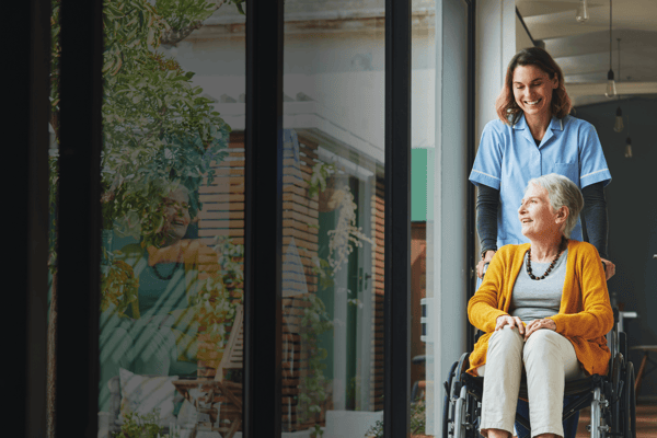 A caregiver assisting a resident in a wheelchair