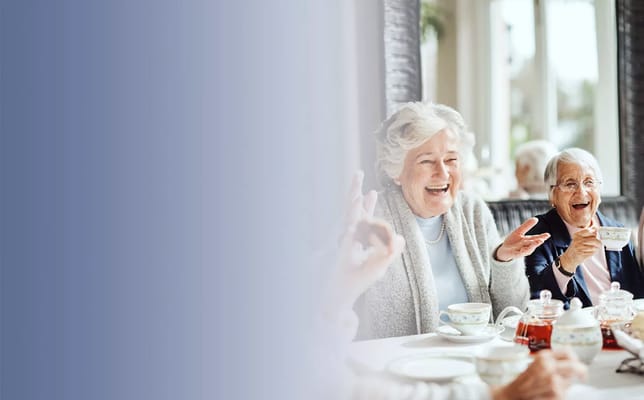 Residents enjoying tea and conversation in a bright dining area