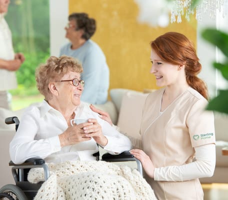 A caregiver smiling with a resident in a common area