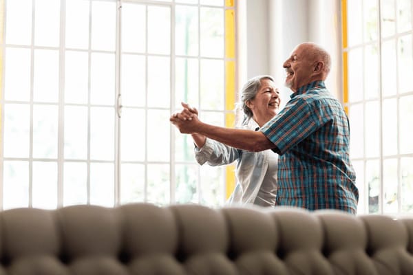 Couple dancing joyfully in a bright common area