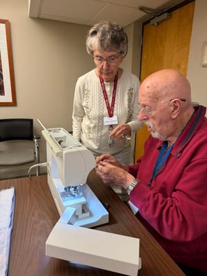 Residents engaging in a sewing activity in a common area