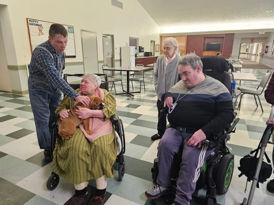 Residents interacting in a common area with staff assistance