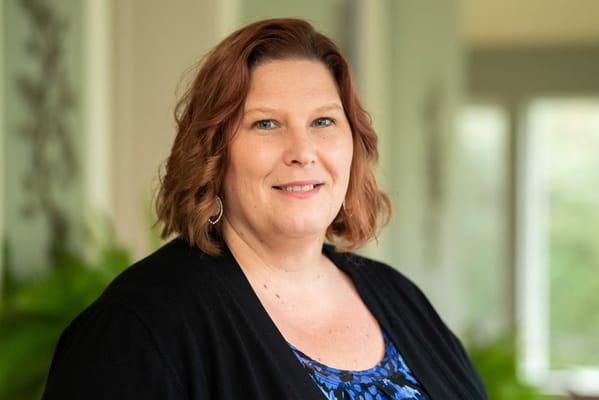 Portrait of a staff member smiling in a well-lit common area