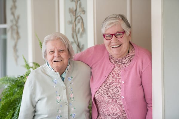 Two smiling residents posing together indoors