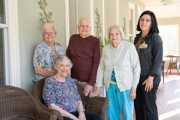 Residents and staff members smiling together in a common area