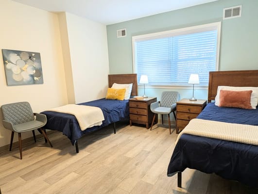 A well-furnished shared resident room with two beds