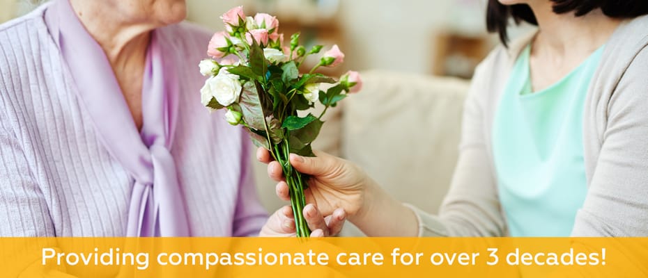 A resident receiving flowers from a caregiver