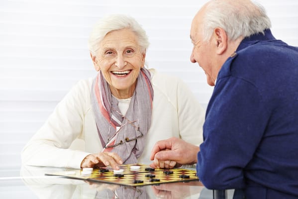 Two seniors playing a board game together