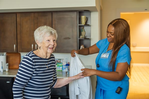 A caregiver assisting a resident in an interior setting