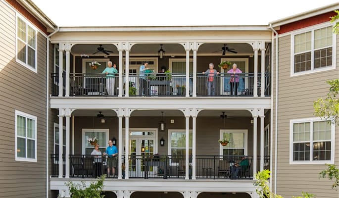 Residents enjoying the balcony of a senior living facility