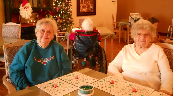 Residents playing bingo in a bright activity room