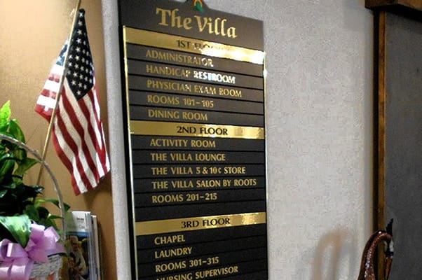 Facility directory sign displaying room numbers and departments