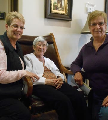 Residents and staff smiling together in a cozy lounge