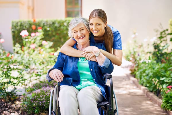 A caregiver and a resident enjoying a garden.