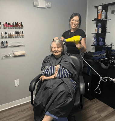 Resident receiving hairstyle treatment at salon