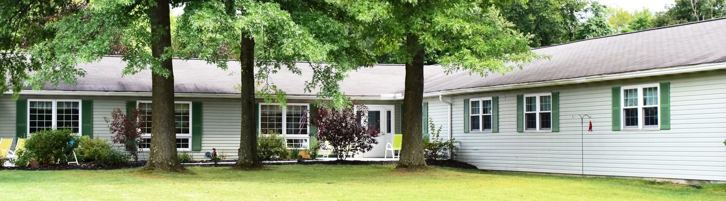 Exterior view of a senior living facility surrounded by trees