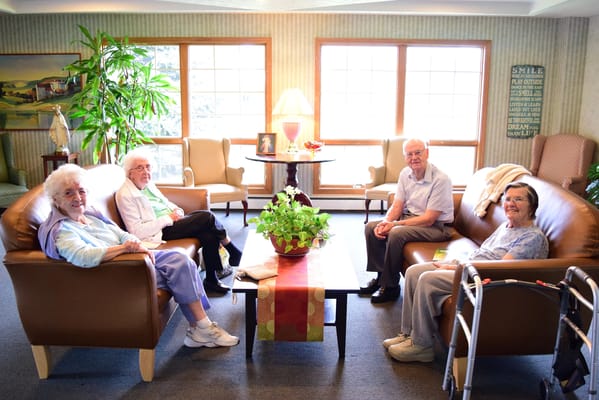 Seniors relaxing in a common area with plants