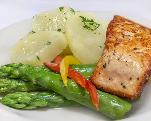Plated meal featuring salmon, potatoes, and asparagus