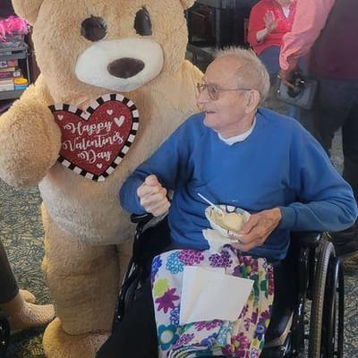Resident enjoying ice cream with a giant teddy bear.