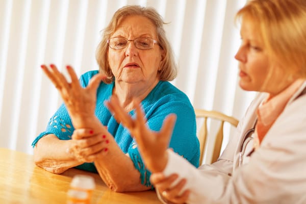A caregiver consulting with a senior resident at a table