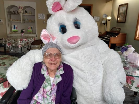 Resident with a costumed bunny in a common area