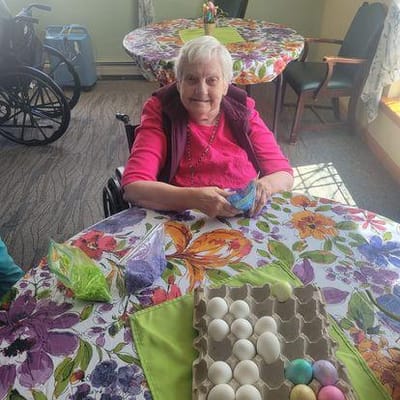Resident decorating Easter eggs at a vibrant activity table