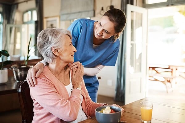 A caregiver and resident enjoying a meal together
