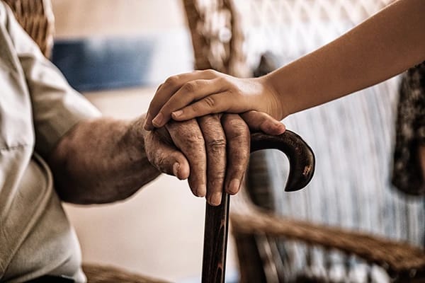 A close-up of elderly hands with a child’s hand resting on top