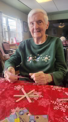Resident enjoying a craft activity at a table