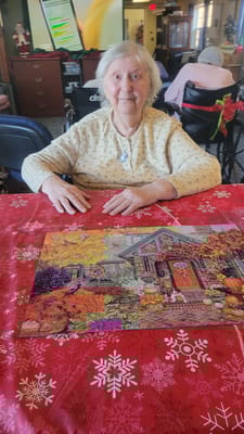 Resident working on a puzzle in a community room