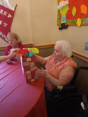 Residents enjoying gift opening activity at the table