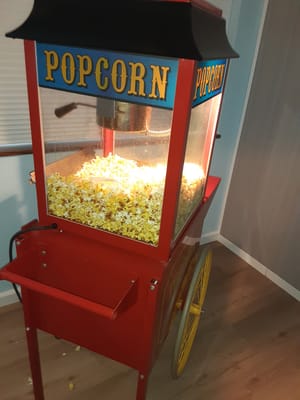 A vintage popcorn machine filled with popcorn