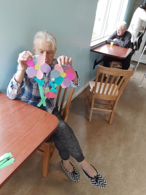 Residents engaged in a craft activity inside the facility