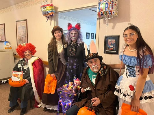 Residents and staff in costumes during a birthday celebration