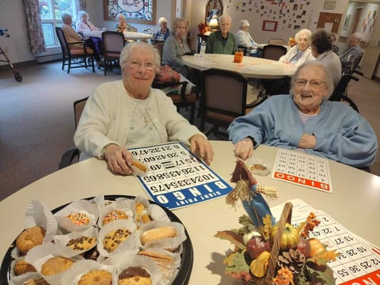 Residents playing bingo with snacks on the table