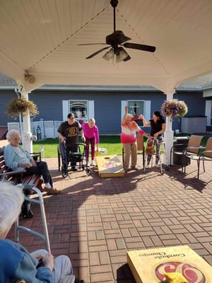Residents participating in an outdoor cornhole game