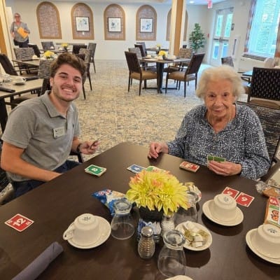 Residents playing a card game in the dining room