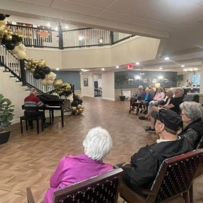 Residents enjoying a live piano performance in a common area
