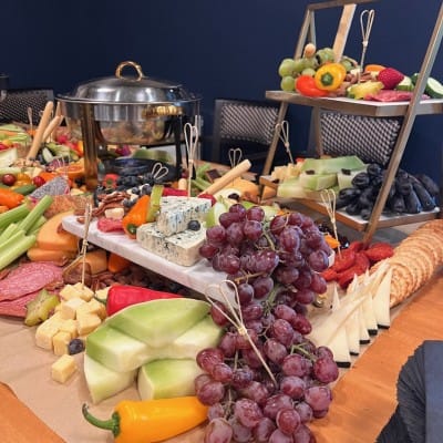 A beautifully arranged food display with various fruits and cheeses