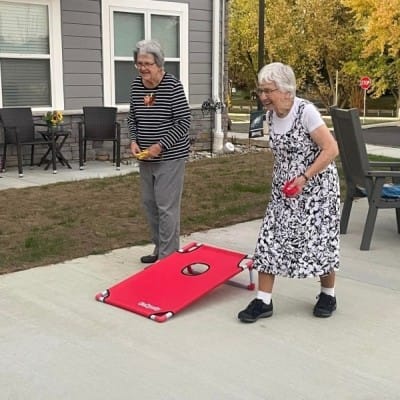 Residents enjoying a game of corn hole outside