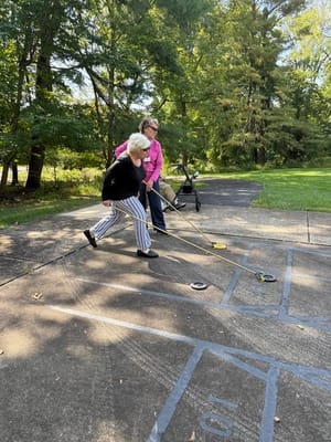 Residents engaged in outdoor activity with a cart