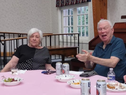 Two residents enjoying a social gathering in the community hall