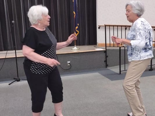 Two residents dancing in a community activity space
