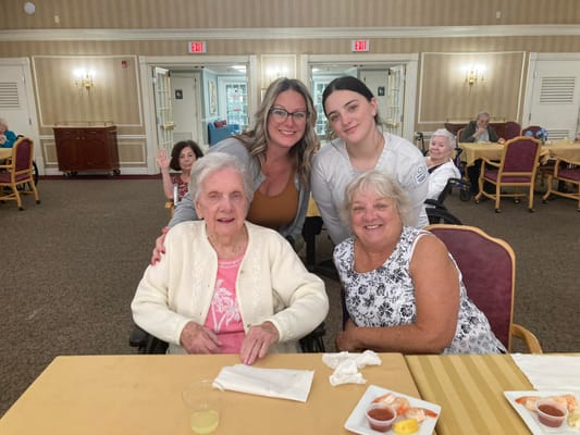 Residents and staff smiling in a dining area