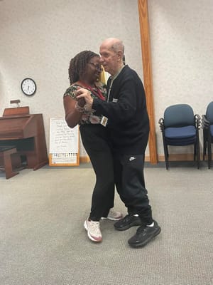 A man and woman dancing in a common area